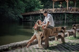 Young married couple in a park near the river, on a date in nature.